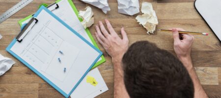 image de quelqu'un qui travaille avec plein de feuille chiffonnées